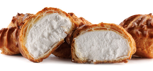 Cut in half and whole porophytroles with white cream on a white background. Eclair with cream.