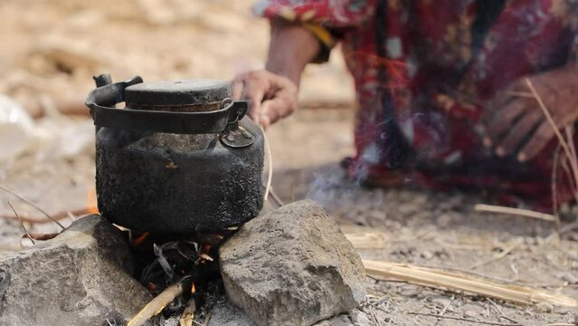 Yemeni woman makes food for her homeless children in displacement campsin the city of Taiz