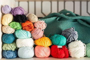 Colorful assortment of yarn balls with knitting bag