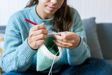 Woman hand-crafting with crochet hook and yarn