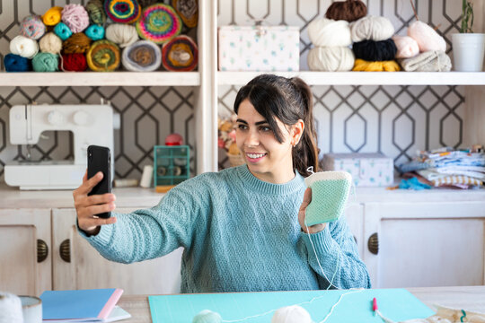 Cheerful craftswoman taking a selfie with her handmade creation