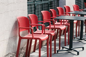 Red chairs of the small cafe in a row at the street of Paris