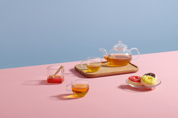 teapot and cup with tea, donuts and honey