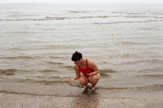 A woman collecting shells in a sea