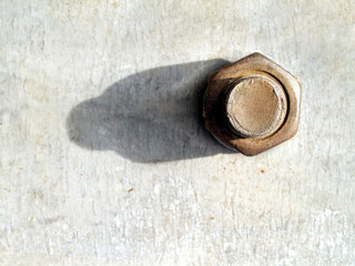 rusty bolt and nut with long shadows on grunge gray steel plate