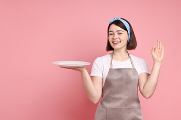 Happy confectioner with plate showing ok gesture on pink background, space for text