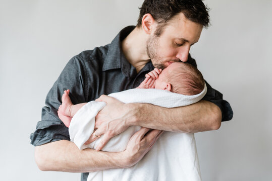 Loving father gives a gentle kiss to his baby