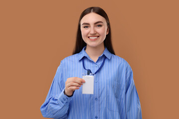 Happy woman with blank badge on brown background