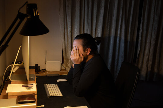 Tired man at night working in front of a computer.