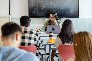 students taking a test under the teacher's supervision