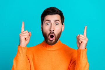 Photo of attractive nice man wear orange stylish clothes buy empty space isolated on cyan color...
