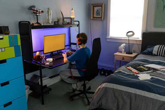 Young Boys fun Portrait Gamer on Computer  home bedroom headphones