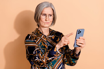 Photo of puzzled senior person with gray hairstyle wear print blouse in glasses look at smartphone...