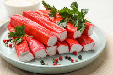 Tasty crab sticks, parsley and spices on table, closeup