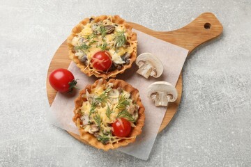 Tasty tartlets with cheese, tomatoes, mushrooms and dill on grey table, top view