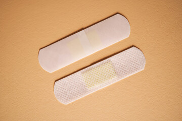 Adhesive plaster on a beige background on both sides.