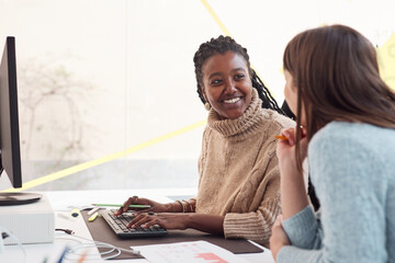 Smiling black woman engaging with colleague at office