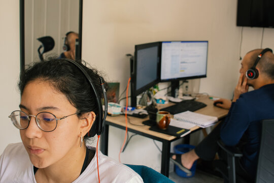 Woman Working from Home Office with boyfriend in Background