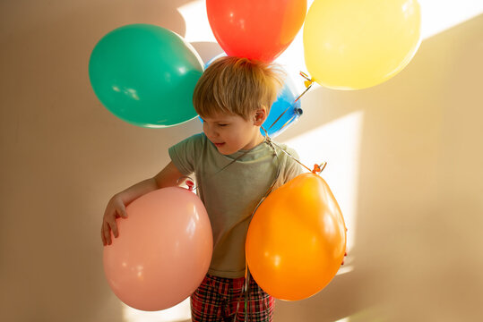 Kid holding colourful balloons