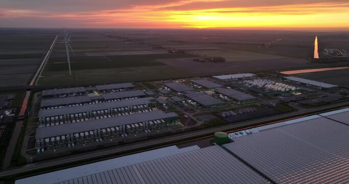 Datacenter internet infrastructure in the Polder of the Netherlands at sunset, dusk. Aerial drone view.