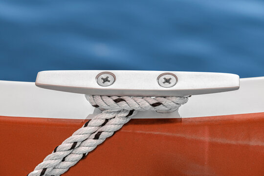 Sailboat cleat and mooring rope against blue sea