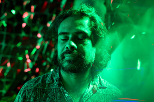 Man enjoying the vibe of music with eyes closed on the dance floor