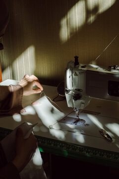 A young Muslim woman putting thread in a sewing machine