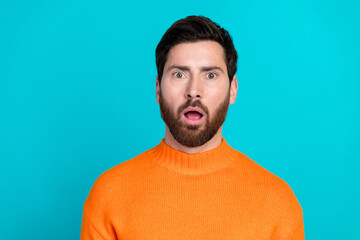 Photo of attractive shocked young man wear orange sweater open mouth isolated on cyan color...
