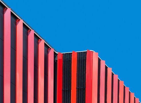 Modern industrial building with red facade against blue sky