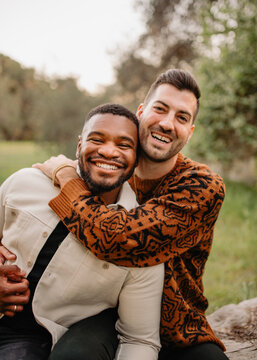 Engaged LGBTQ+ couple posing smiling at the camera