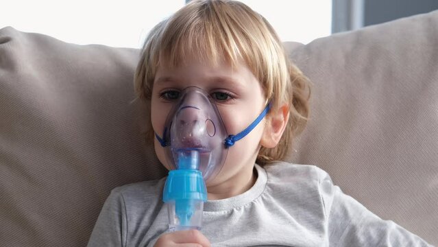 little boy using steam inhaler nebulizer. health medical care.