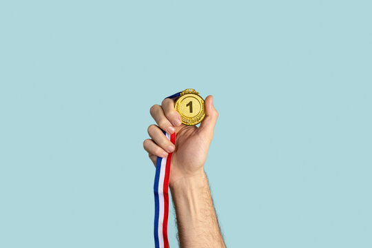 Person holding first prize gold medal. Success, competition, winner.
