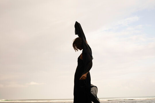 Abstract female dance on beach in sunrise
