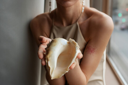 Anonymous woman holding a seashell