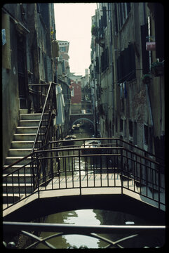 Old film photo. Cityscape of Venice canal with boats and bridges