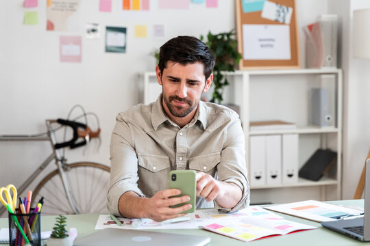 Man Browsing Smartphone in Office