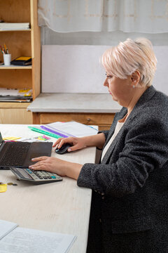 Accountant working at a laptop in the office among documents