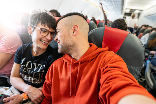 Happy couple traveling on a plane.