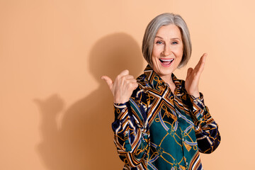 Photo of funky retired person with gray hairdo wear print blouse indicating at offer empty space...