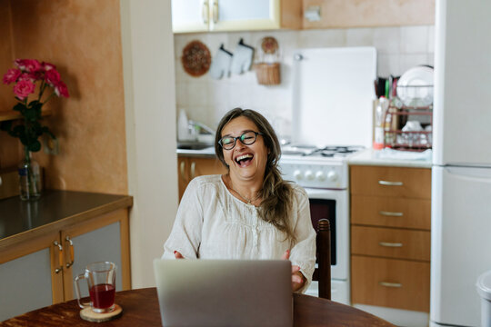 Adult woman working from home using laptop for a video call