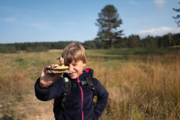 Portrait of a boy examining a mushroom