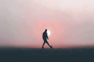 person walking with a ball against a bright sunrise sky creating a serene atmosphere