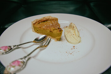 Pumpkin pie slice with whipped cream and utensils