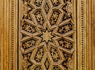 Carved antique wooden doors with patterns and mosaics.