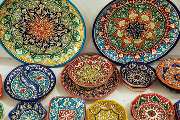Traditional ceramics of Central Asia. Ancient traditional Uzbek ceramic dishes with national ornaments. Colorful handmade ceramics from Uzbekistan.