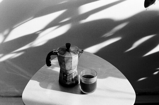 Geyser coffee maker and a cup in a table