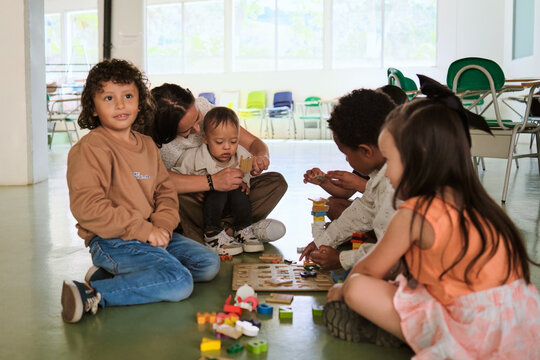 Teacher with her students playing on the floor