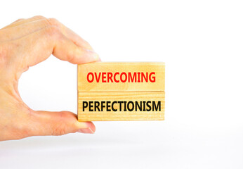 Overcoming perfectionism symbol. Concept words Overcoming perfectionism on beautiful wooden block. Beautiful white background. Businessman hand. Business Overcoming perfectionism concept. Copy space.
