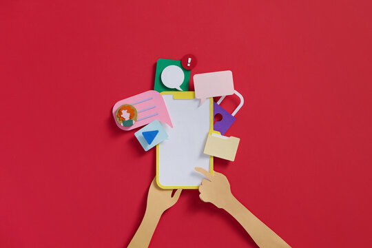 Hand holds smartphone with application icons around