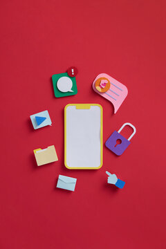 Mobile phone under colorful application icons on red background